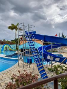 a blue water slide in a swimming pool at Hotel Pousada Viking in Jacumã