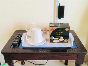 Dala Studio - Beach Road في مومباسا: طاولة قهوة مع صندوق وكوب من القهوة