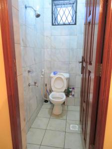 a bathroom with a toilet and a shower at Dala Studio - Beach Road in Mombasa