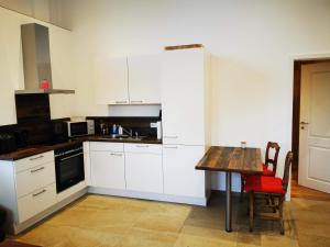 cocina con armarios blancos y mesa de madera en Ferienwohnung Fuchs en Münster