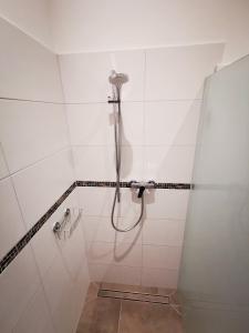 a shower in a bathroom with white tiles at Ferienwohnung Fuchs in Münster