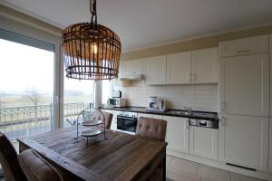 a kitchen with a wooden table and a chandelier at Villa Seeluft - by Rujana in Ostseebad Sellin +63 photos