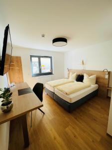 1 dormitorio con cama, mesa y escritorio en Creo München Süd en Múnich