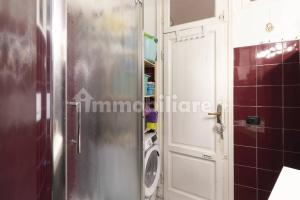 a bathroom with a door and a washing machine at Incantevole appartamento accanto fondazione Prada in Milan