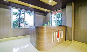 a hotel lobby with a reception desk and two windows at Treebo Balaji Excellency in Mahabaleshwar