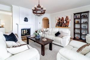 a living room with white furniture and a chandelier at LAP- 3 bed apartment on the beach. Families only in Casares