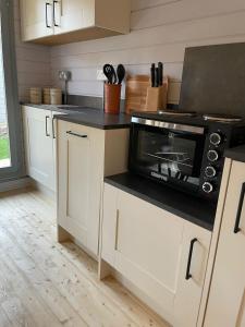 a kitchen with a microwave oven on a counter at Cromwell Lodge, Cromer, moments from the beach! in Cromer
