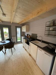 a kitchen and dining room with a table and a counter at Cromwell Lodge, Cromer, moments from the beach! in Cromer