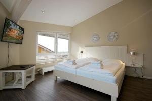 a bedroom with a large white bed and a window at Villa Seeluft - by Rujana in Ostseebad Sellin