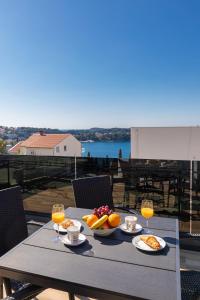 einen Tisch mit Speisen und Getränken auf dem Balkon in der Unterkunft Apartments Sweet and Cozy in Cavtat