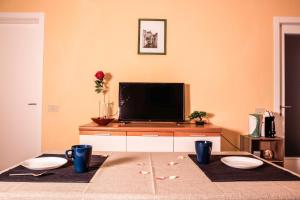 een woonkamer met een tv en een tafel met twee borden bij Netflix - Centro Storico Urbino in Urbino