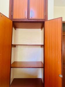 an empty closet with wooden shelves and cabinets at Dala Studio - Beach Road in Mombasa