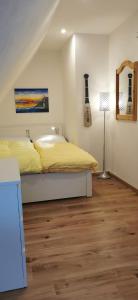 a bedroom with a yellow bed and a lamp at Kleine Auszeit Pellworm in Pellworm