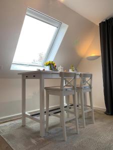 einen Tisch und zwei Stühle in einem Zimmer mit Fenster in der Unterkunft Kleine Auszeit Pellworm in Pellworm