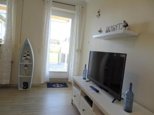 a living room with a flat screen tv on a dresser at Scheitz 1 in Dahme