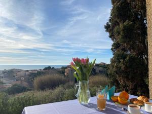 a table with a vase of flowers and some oranges at ULVF Les Romarins in Fleury