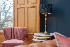 a room with a lamp and a table and chairs at South Learmonth Gardens Apartment in Edinburgh