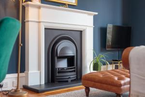 a living room with a fireplace and a couch at South Learmonth Gardens Apartment in Edinburgh