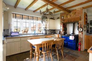 a kitchen with a wooden table and chairs at Blounts Court Farm in Devizes