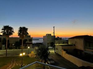 a view of the ocean at sunset from a balcony at Aria apts 100 m from the beach by PosarelliVillas in Kolymvari