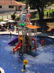 a group of children playing in a swimming pool at Hotel Fazenda Santa Barbara in Engenheiro Paulo de Frontin