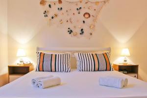 a bedroom with a white bed with towels on it at Little House Orebić in Orebić