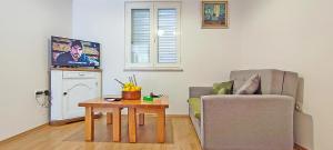 a living room with a chair and a table at Little House Orebić in Orebić