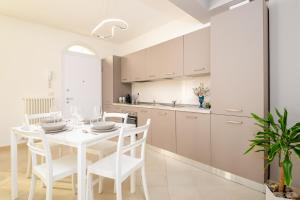 a white kitchen with a white table and chairs at Appartamento Ercole in Sestri Levante