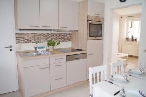 a kitchen with white cabinets and a sink and a table at Scheitz 1 in Dahme