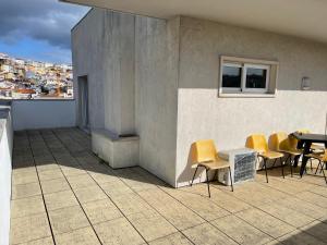 een patio met gele stoelen en een tafel in een gebouw bij Miguel Torga Diamond Penthouse in Coimbra
