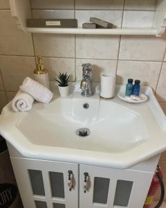 un lavabo blanco en el baño con toallas. en Dream House Efi, en Ravdhoúkha