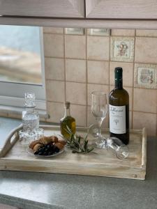 a wooden tray with a bottle of wine and a glass at Dream House Efi in Ravdhoúkha