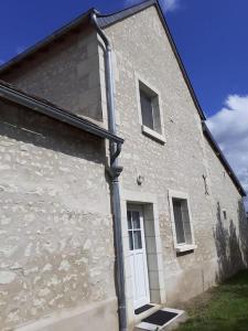 a building with a white door on the side of it at Le Gîte de Martine et Marc in Sazilly