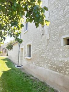 un edificio de ladrillo blanco con un patio de hierba al lado en Le Gîte de Martine et Marc, en Sazilly