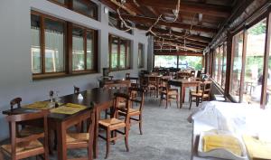 un comedor con mesas, sillas y ventanas en Wolf Village, en Demonte