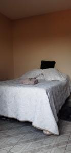 1 dormitorio con 1 cama con edredón blanco en Cantinho da Bisa, en Campos do Jordão