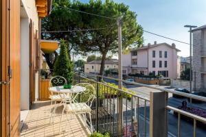 einen Balkon mit einem Tisch, Stühlen und einer Straße in der Unterkunft Bed & Breakfast Lucy in Bardolino