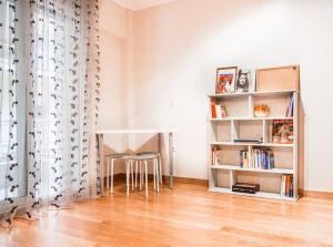 una sala de estar con una mesa y un estante de libros en Wood apartment in the center of Thessaloniki, en Tesalónica