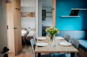 a dining room with a table and chairs with flowers on it at Mobil Home XXL 4 chambres - Camping Le Barberousse in Gruissan