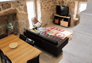 sala de estar con sofá de cuero y mesa en Batoca by Burra Velha - Private House, en Celorico de Basto
