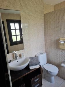 a bathroom with a toilet and a sink and a mirror at Hostal Asador Julian in Brunete