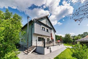 a green and white house with a balcony at MIRA by Atra in Teşila