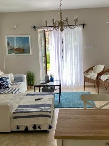 a living room with two beds and a chandelier at Villa Scamard in Zamárdi