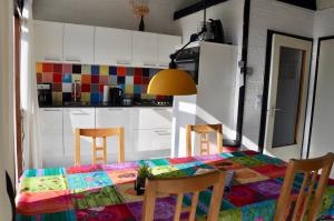 a kitchen with a table with a colorful tablecloth on it at Boerenslag 10 in Sint Maartensvlotbrug +3 photos