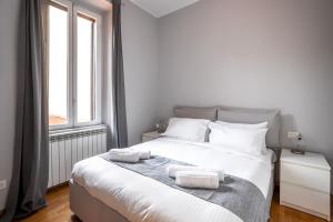 a bedroom with a large white bed with towels on it at [NAVIGLI-DUOMO] Apartment with Netflix+Wifi in Milan