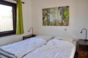 una camera da letto con un letto e un dipinto sul muro di Boerenslag 10 a Sint Maartensvlotbrug