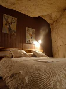 a bedroom with a large bed and two pictures on the wall at Les Troglos de Beaulieu in Loches