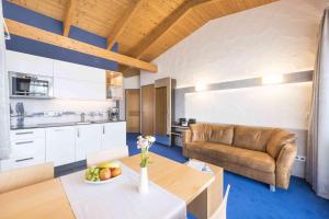 a kitchen and living room with a couch and a table at Appartement Hotel Seerose in Immenstaad am Bodensee +19 photos