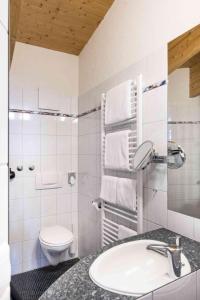 a white bathroom with a sink and a toilet at Appartement Hotel Seerose in Immenstaad am Bodensee