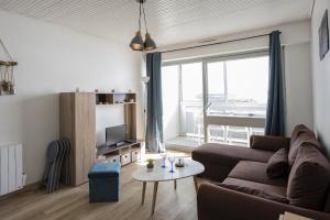 een woonkamer met een bank en een tafel bij Venez profiter de ce bel appartement situe a Saint Hilaire de Riez in La Parée Preneau